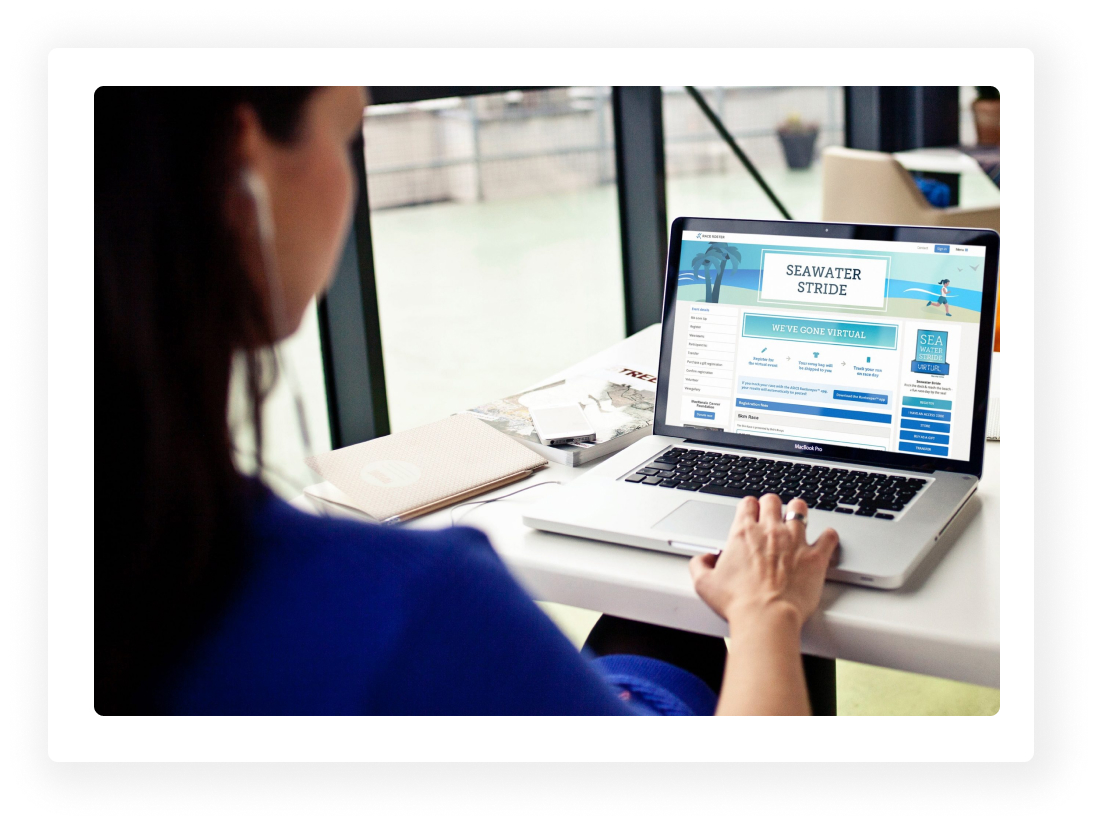 Woman looking at a laptop with a Race Roster event details page on the screen